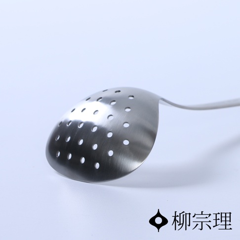 一個帶有圓形孔洞的不鏽鋼杓，杓面呈半圓形，材質為銀色不鏽鋼，整體為廚房用具。