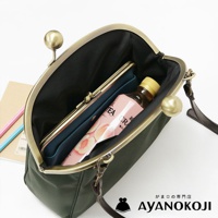 AYANOKOJI 綠色斜背包，打開的包內有化妝包、飲料和筆。