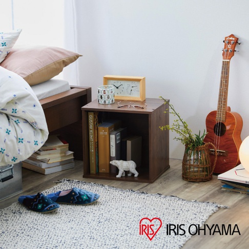 深棕色立方體組合收納櫃，側面可見書本、時鐘、眼鏡，櫃內有書本和白色小熊擺飾。