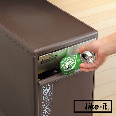 棕色三層分類垃圾桶，上方抽屜打開，一只手將一個綠色啤酒罐投入。垃圾桶側面有「CAN」、「Aluminum Steel」、「BIN」等分類標籤。