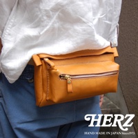 職人手作皮革兩用腰掛斜背包，深棕色皮革，附有拉鍊主袋和前置拉鍊袋，車縫線清晰，適合腰掛或斜背。