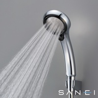 銀色金屬材質的蓮蓬頭，正噴射出細緻的水流，蓮蓬頭上有品牌標誌。