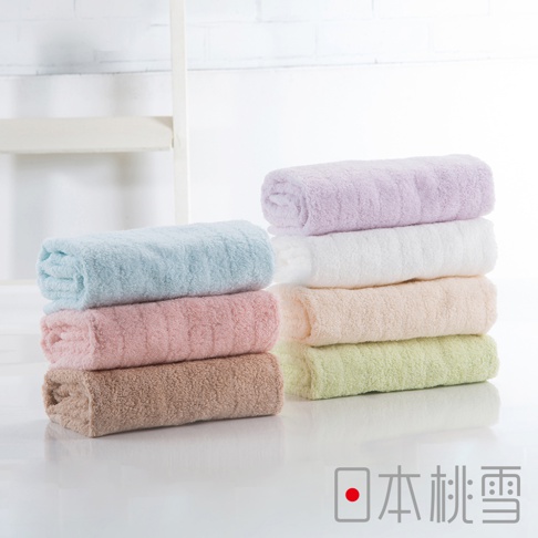 今治超長棉浴巾堆疊展示，包含淺藍、粉紅、淺棕、淡紫、白色、淺膚色及淺綠色，材質柔軟，質感細緻。