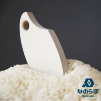 由珪藻土製成的白色米勺，置於裝滿稻米的碗中，背景為深灰色。右下角有NANOLABO品牌標誌及日文與英文名稱。