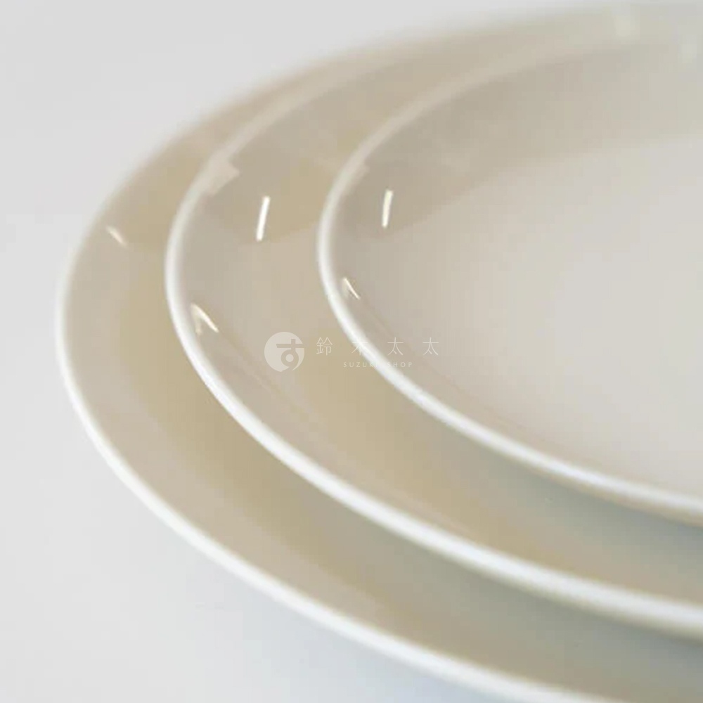 三層疊放的CouLeur美濃燒圓形餐盤，呈現簡約素雅的米白色調，盤面光滑，邊緣圓潤，具有陶瓷質感。