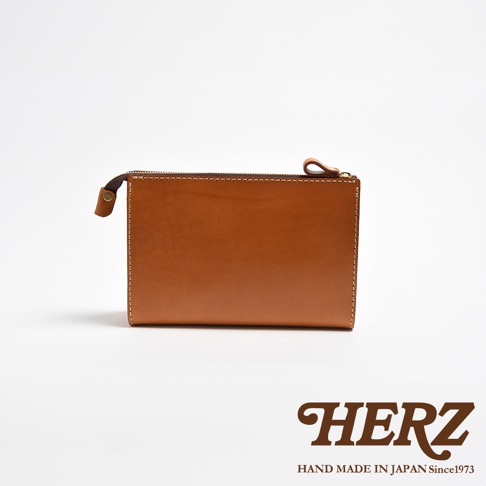 職人手作皮革三角底拉鍊手拿包，採用光滑的棕色皮革，搭配金屬拉鍊，簡約俐落，適合各種場合。