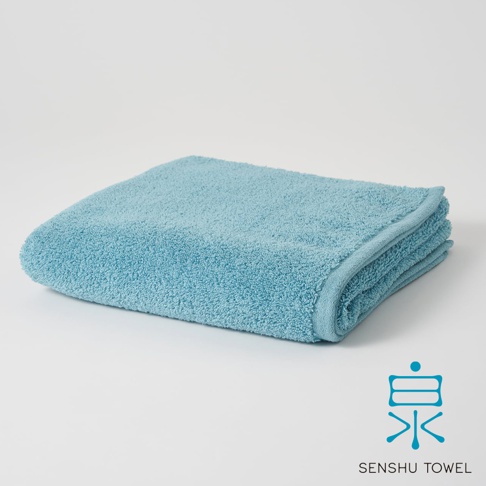 淺藍色長纖迷你浴巾，材質柔軟，邊緣縫線整齊，呈現蓬鬆質感。