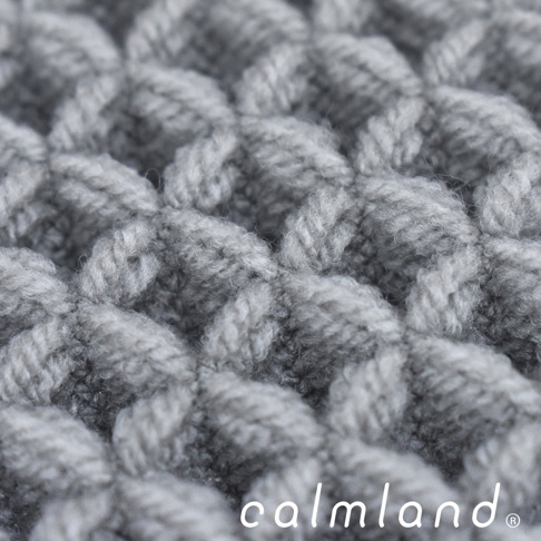 近拍灰色七層紗織物的紋理，織法交錯，質地柔軟蓬鬆。