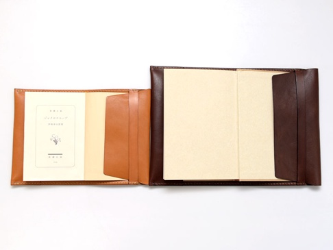 職人手作皮革翻蓋記事本書套，淺褐色與深褐色皮革拼接設計，打開狀態，展示內裡卡槽與素色內頁。