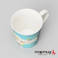 白色陶瓷馬克杯，外圍印有淺藍色背景的北海道地圖，標示著城市、景點和「PACIFIC OCEAN」字樣，杯身繪有燈塔、帆船等圖案。