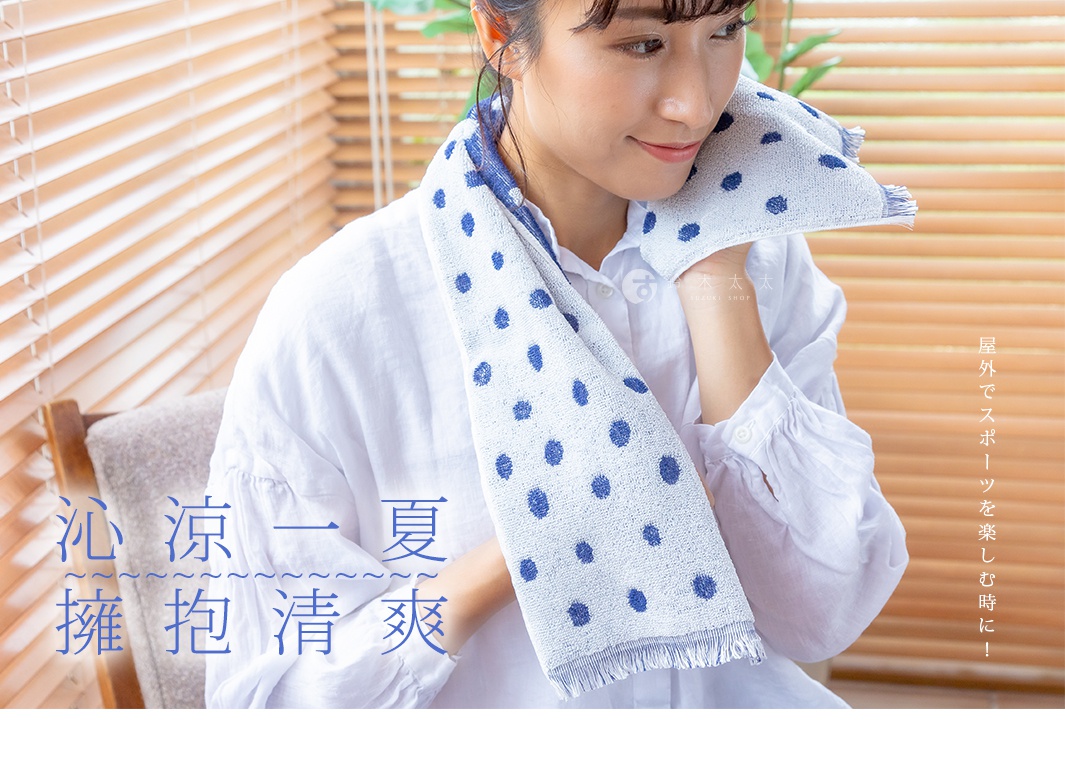 一位女性使用藍色圓點圖案的嫘縈毛巾，毛巾材質輕薄，觸感涼爽，毛巾邊緣有流蘇設計，適合戶外活動時使用。