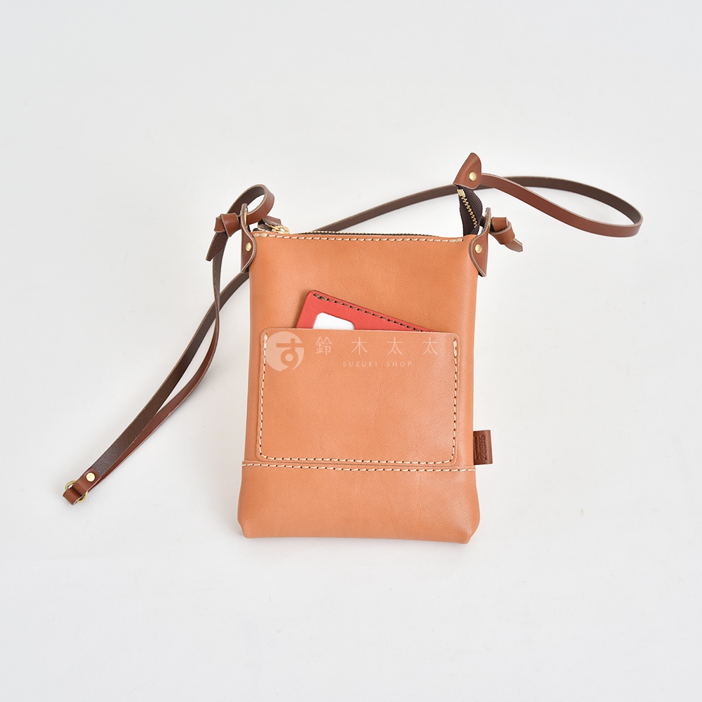 職人手作皮革直式隨身單肩包，淺棕色，有正面插袋，可放卡片，搭配長背帶。