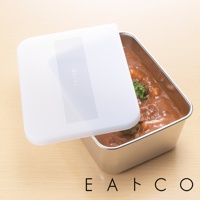 日製不鏽鋼食物儲存盒，盒身為銀色金屬材質，盛裝著咖哩飯，蓋子為白色塑膠材質，上面印有灰色「EATCO」字樣。