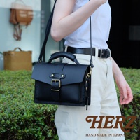 黑色皮革迷你單肩包，附有頂部提把、可調式肩帶及金色釦環。