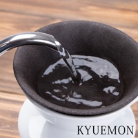 黑色濾杯組，內部有水正在注入，濾杯外層為白色支架，背景為木紋桌面。