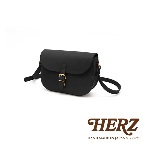 黑色皮革經典馬鞍包，設有金屬釦環與可調式肩帶，簡約設計，適合日常搭配。