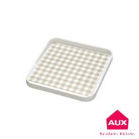 白色塑膠迷你砧板，表面有米白色格紋防汙紙，四周有淺灰色邊緣，右下角有粉紅色房屋形狀的 AUX 品牌標誌。