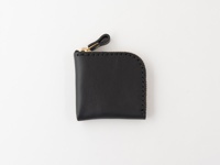 黑色皮革製成，L型拉鍊零錢包，搭配金色拉鍊頭和皮革拉環，邊緣有車縫線裝飾，整體簡約。