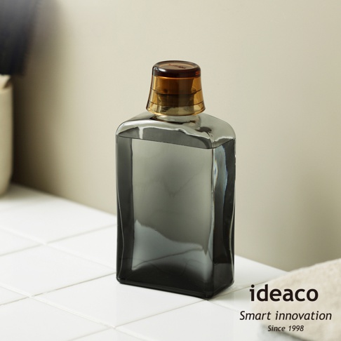 ideaco 復古風漱口水專用玻璃瓶，搭配琥珀色瓶蓋，瓶身呈現深灰漸層，瓶底置於白色磁磚上。