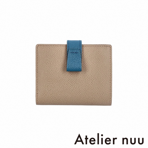 Atelier nuu 品牌 logo 下方為一個米色皮革材質的雙折短夾，上有藍色皮革製成的按扣，呈現簡約風格。