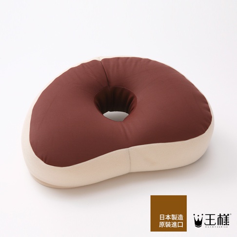 王樣午睡枕，咖啡色與米白色拼接，中間有圓形開口，材質柔軟，適合午休時使用。