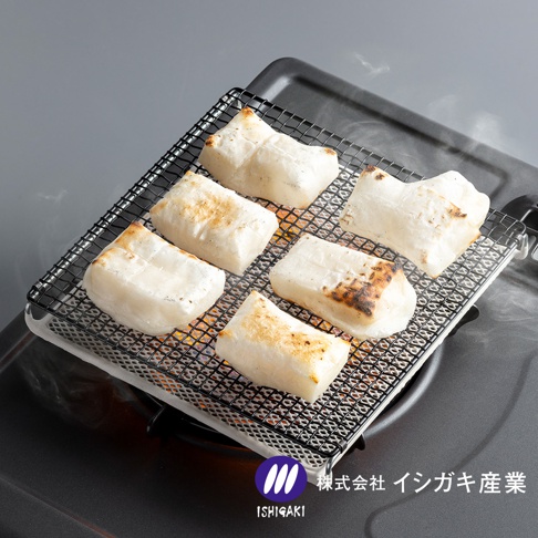 一個方形陶瓷烤網置於瓦斯爐上，網架上整齊擺放著六塊正在烘烤、表面略帶焦香色澤的白色年糕，右下角印有石垣產業的品牌標誌與名稱。