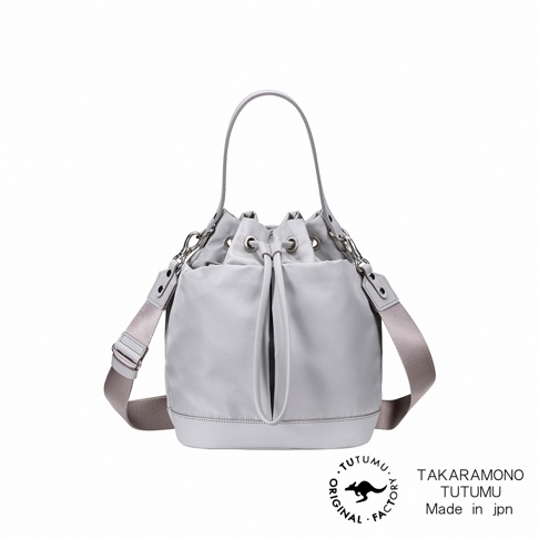 TUTUMU 灰色抽繩水桶包，配有可拆卸斜挎肩帶和頂部提手，袋身有品牌標誌。