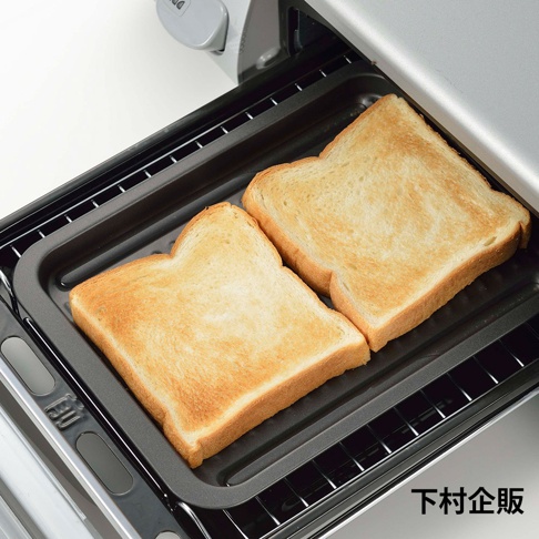 灰色金屬烤箱內，黑色波浪烤盤上擺放著兩片金黃色的烤吐司。