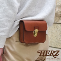 經典棕色皮革腰包，以手工縫製，搭配金色搭扣，可繫於腰間，風格簡約實用。