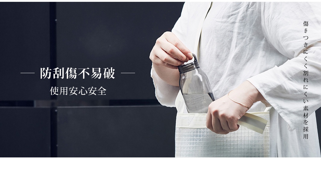 透明灰色塑膠輕水瓶，瓶身內含飲用水，瓶蓋處有提環，手持水瓶置於米白色網格袋中。