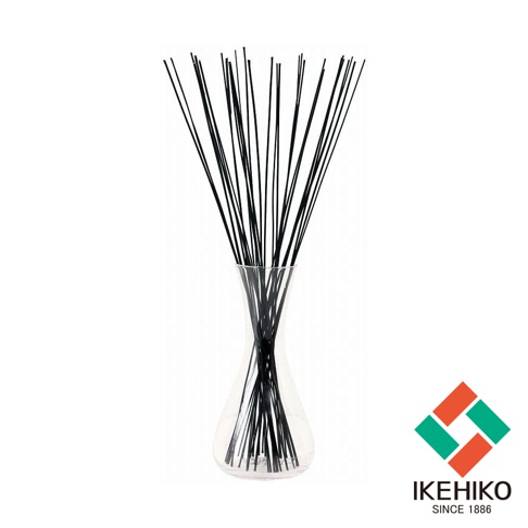 玻璃花瓶中插有大量細長的黑色藺草，草束在花瓶頂部散開，露出草的頂端。