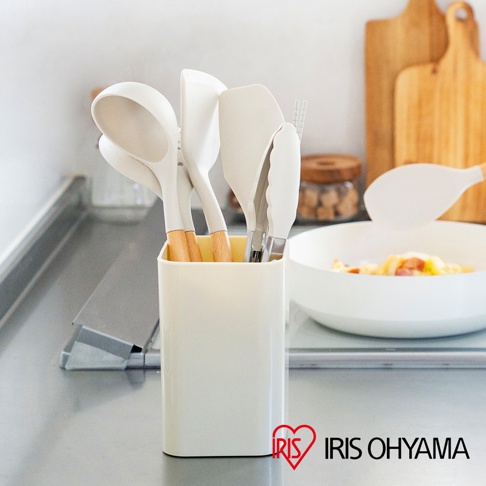 米白色收納架內有湯勺、鍋鏟、夾子等白色矽膠廚房用具，部分用具帶有木質手柄。