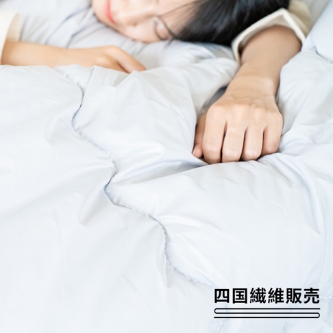 淺藍色雙人SOFAIR WARM+5℃無重力空氣暖被，表面光滑，有細緻的縫線，露出部分為女性的臉部和手臂。