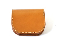 職人手作皮革馬蹄造型零錢包，採用自然色皮革製成，邊緣以白色縫線滾邊，呈現經典簡約的馬蹄形狀。