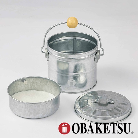 OBAKETSU 品牌標誌，展示一個鍍鋅鋼製小垃圾桶、一個裝有白色粉末的小圓形桶，以及一個配套的蓋子，背景為白色。