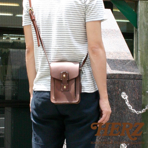 職人手作皮革散步包，深棕色，方正小巧，附有翻蓋及按扣，可斜肩背。