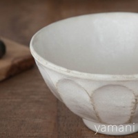 米白色陶瓷丼碗，碗身有六道凹紋，邊緣帶有仿舊的土黃色澤，碗底有品牌浮水印。