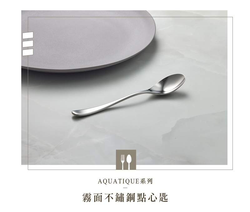 霧面不鏽鋼點心匙，銀色，以簡約的線條設計，搭配灰色的盤子，置於大理石紋的桌面。