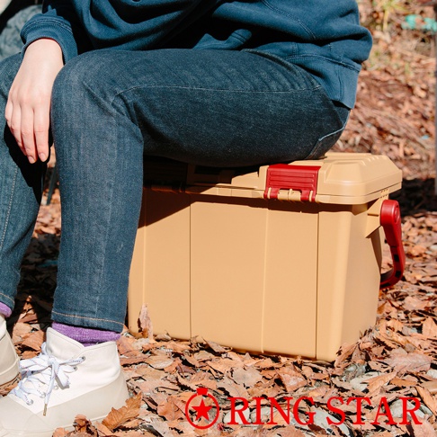 Starke-R 超級箱，一個淺棕色的塑膠儲物箱，配有紅色扣環和可折疊提把，置於落葉地面上。