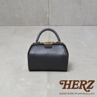 黑色皮革手提包，帶有金色口金開關和提把，展現簡約的方形設計。