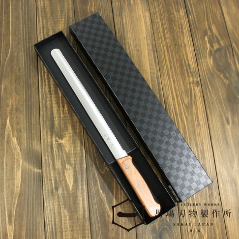 [堺一次] 不鏽鋼麵包刀，刀刃為鋸齒狀，配有淺棕色木質握柄，置於黑色長形禮盒內，禮盒上蓋為深灰色格紋。