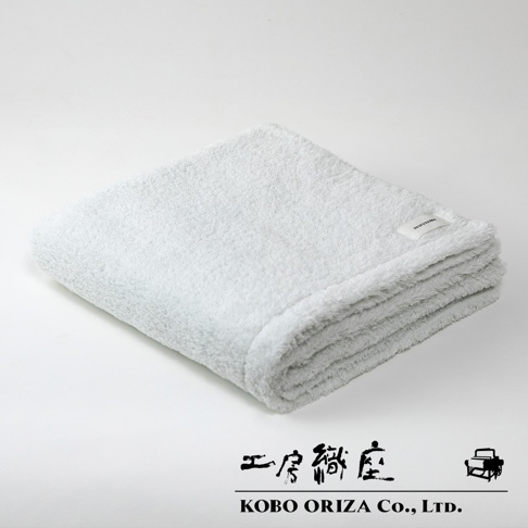 MOFA 今治柔感極甘撚系匹馬棉浴巾，白色，柔軟蓬鬆的質地，質樸的標籤標示著品牌。