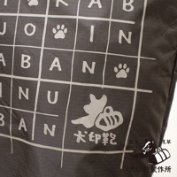 深灰色環保折疊收納購物袋，表面印有白色網格、字母、狗爪圖案及「犬印鞄」品牌標誌，材質為尼龍。