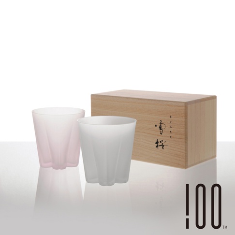 雪櫻杯威士忌杯組，包含一個淺粉色和一個白色霧面玻璃杯，杯身有放射狀凹槽設計，搭配一個木製禮盒，盒上印有日文「さくらさく」與「櫻」字樣。