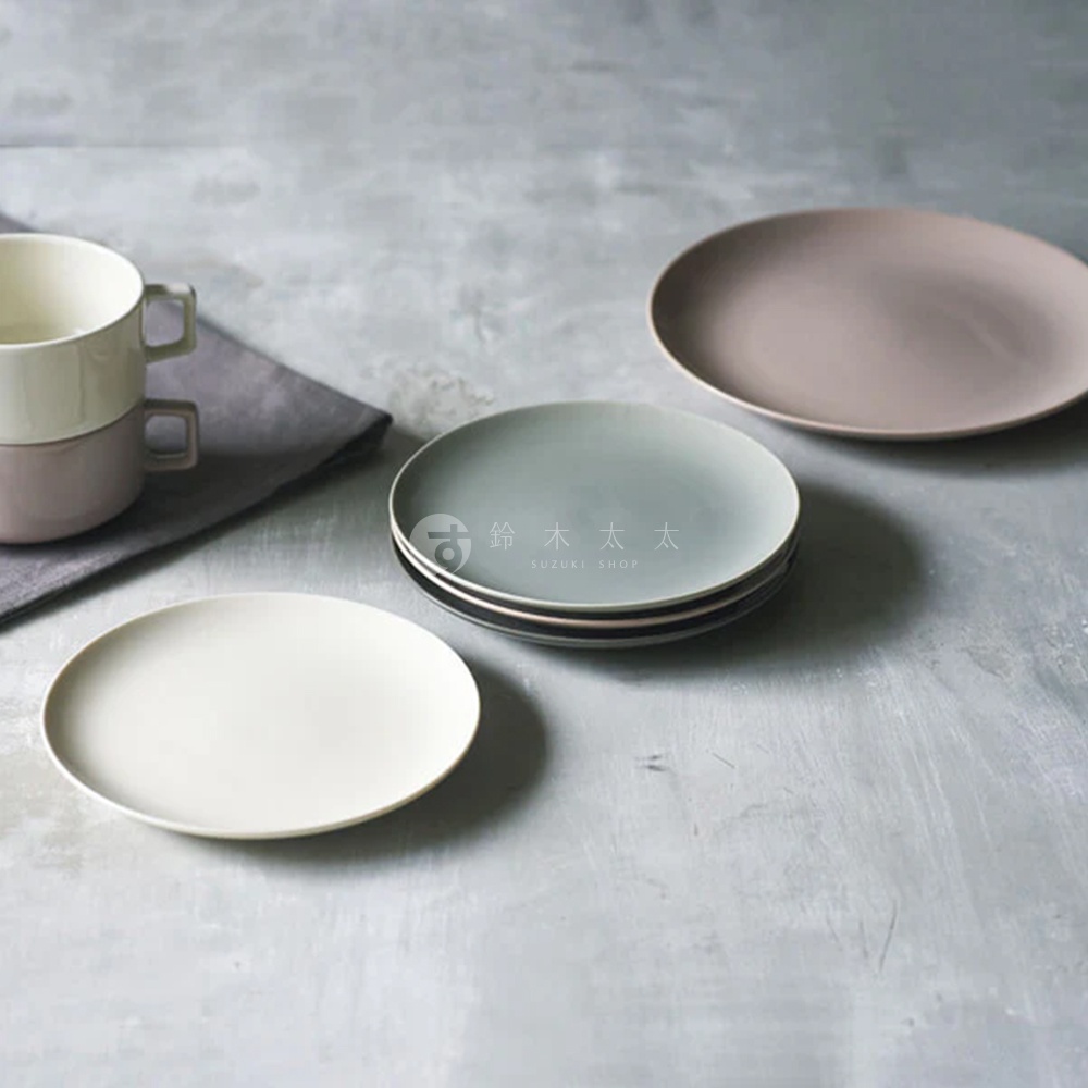 CouLeur 美濃燒簡約素雅圓盤，共展示三款顏色：米白色、淺灰藍及淡粉色。盤面光滑，邊緣略有厚度，搭配疊放的灰色系陶瓷杯，呈現樸實質感。
