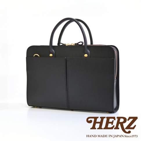 黑色皮革雙口袋兩用商務公事包，設有頂部提把、金色拉鍊及金屬釦，整體採用簡約風格設計。