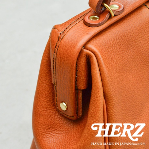 職人手作皮革Organ方形口金托特包，特寫展示棕色皮革的紋理、金屬口金及縫線細節。