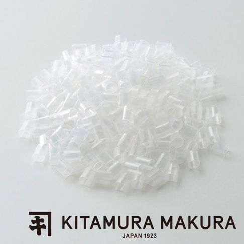 一堆透明、圓柱狀的軟管零件，堆疊在淺灰色背景上，角落有「KITAMURA MAKURA JAPAN 1923」的標誌。