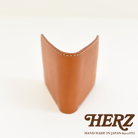 棕褐色皮革二折橫式小短夾，簡潔設計，車縫線清晰，展現職人手作質感。