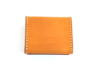 職人手作皮革箱型收納零錢包，採用天然皮革材質，呈現溫潤的焦糖棕色，邊緣以米白色縫線手工縫製，設計簡約實用。